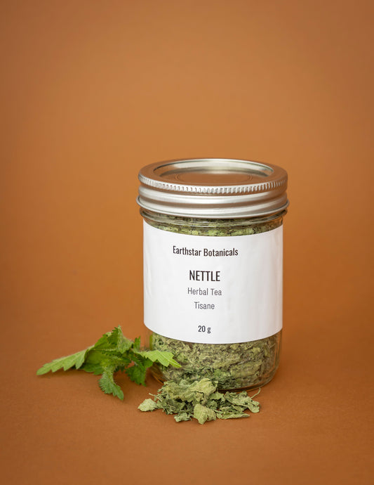 Jar of Earthstar Botanicals Nettle Herbal Tea on an orange background